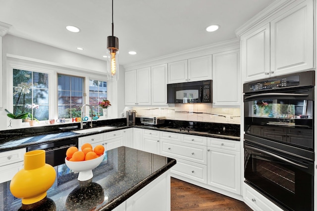 kitchen featuring white cabinetry, sink, dark stone countertops, hanging light fixtures, and black appliances