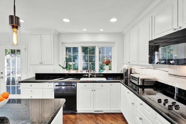 kitchen featuring white cabinetry, sink, dark stone countertops, hanging light fixtures, and black appliances