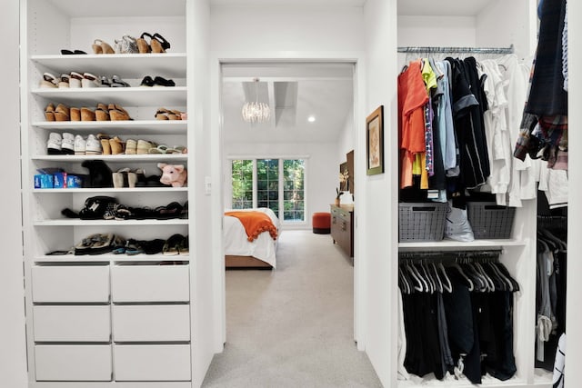 walk in closet with light carpet