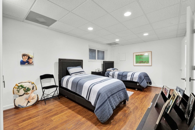 bedroom featuring wood-type flooring and a paneled ceiling