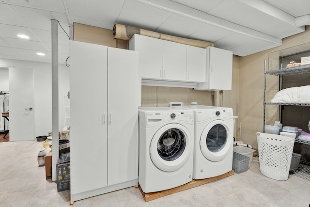 laundry room featuring washer and clothes dryer and cabinets