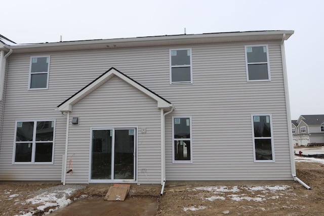 view of snow covered back of property