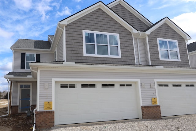 craftsman-style home featuring an attached garage and brick siding