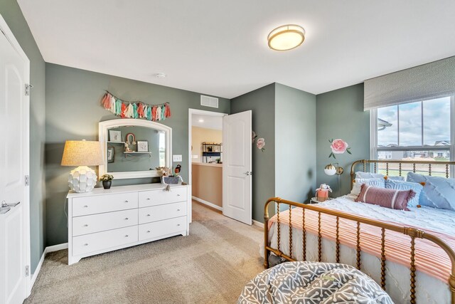 bedroom with baseboards, light carpet, and visible vents
