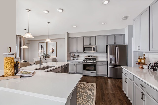 kitchen featuring visible vents, gray cabinetry, a sink, light countertops, and appliances with stainless steel finishes