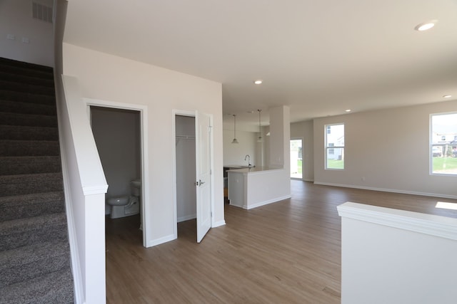 interior space featuring plenty of natural light, stairs, wood finished floors, and visible vents