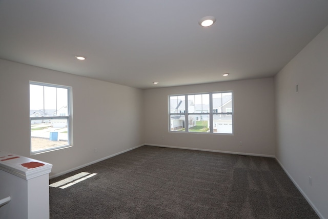 empty room with recessed lighting, baseboards, and dark carpet