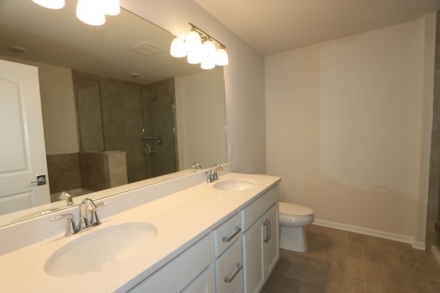 bathroom with double vanity, a sink, a stall shower, and toilet