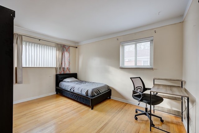 bedroom featuring crown molding and light hardwood / wood-style floors