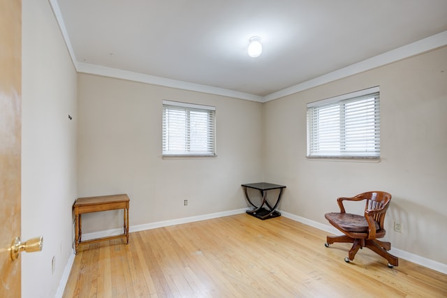 living area featuring hardwood / wood-style flooring and ornamental molding