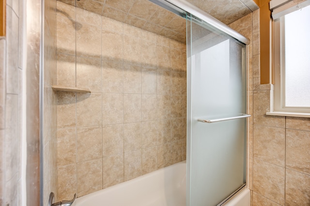 bathroom with shower / bath combination with glass door