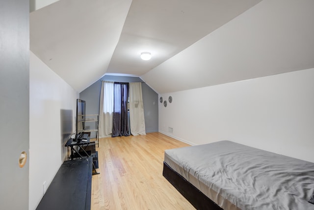 bedroom with vaulted ceiling and wood-type flooring