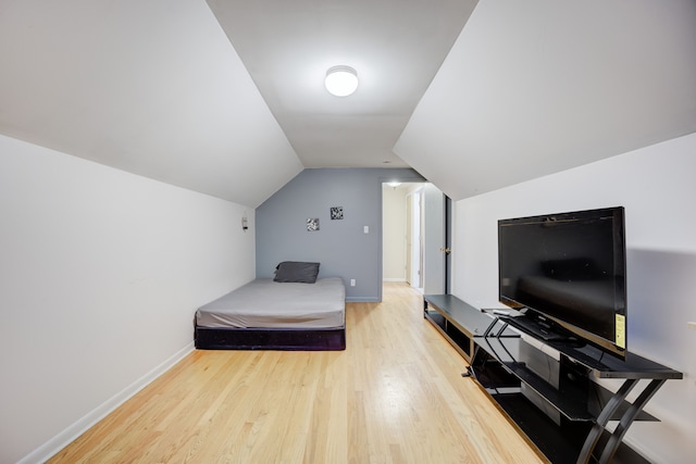 bedroom with lofted ceiling and light hardwood / wood-style flooring