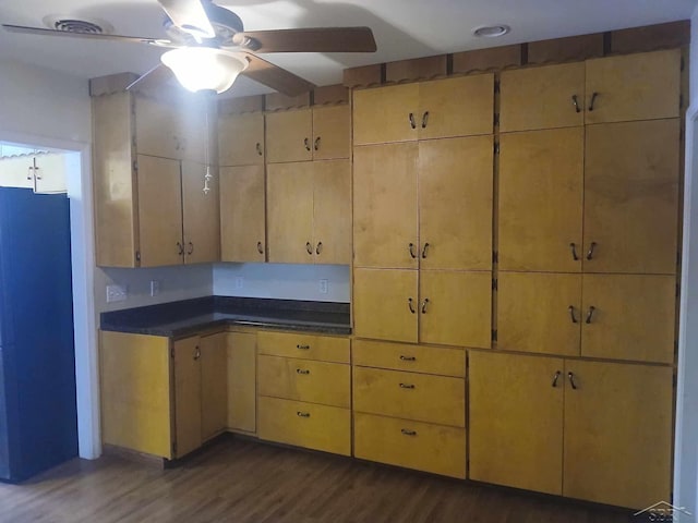 kitchen with fridge, dark wood-type flooring, and ceiling fan