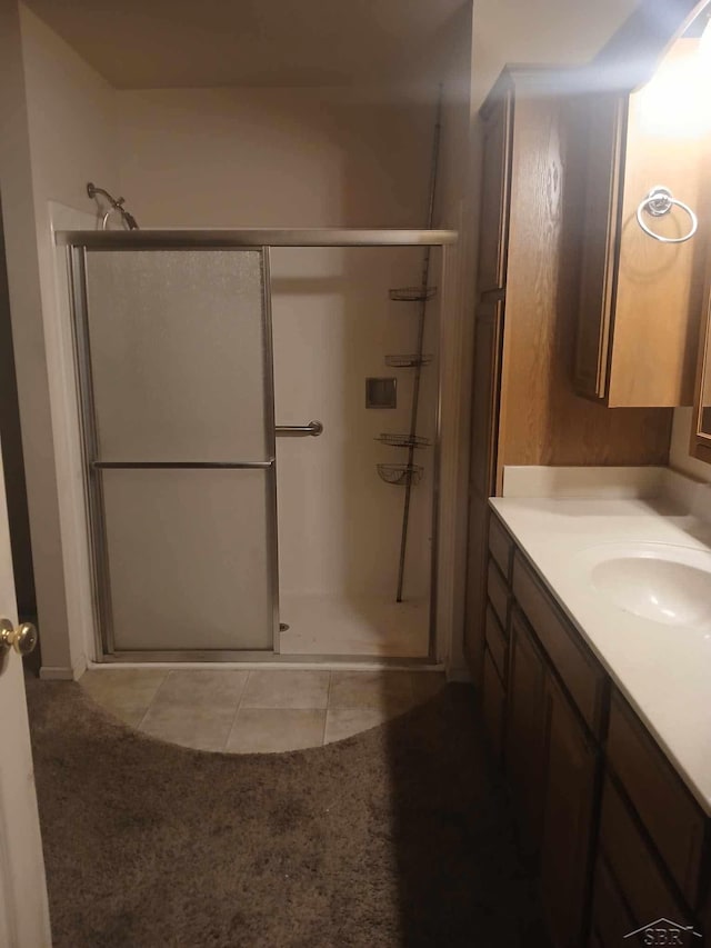 bathroom with tile patterned flooring, vanity, and an enclosed shower