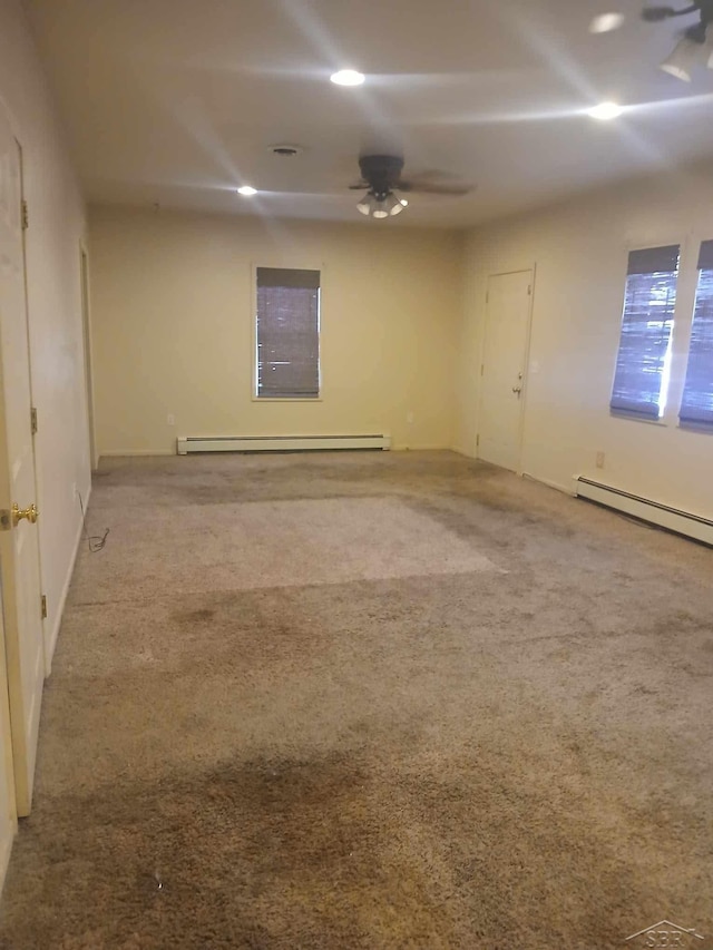 spare room featuring carpet, a baseboard heating unit, and ceiling fan