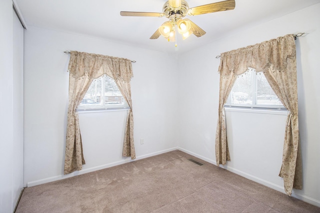 carpeted empty room featuring ceiling fan