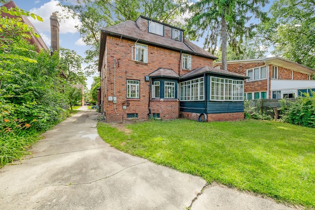 rear view of property with a yard and a sunroom