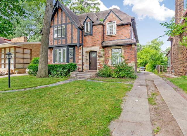 english style home featuring a front yard