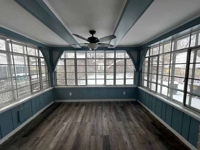 unfurnished sunroom with ceiling fan