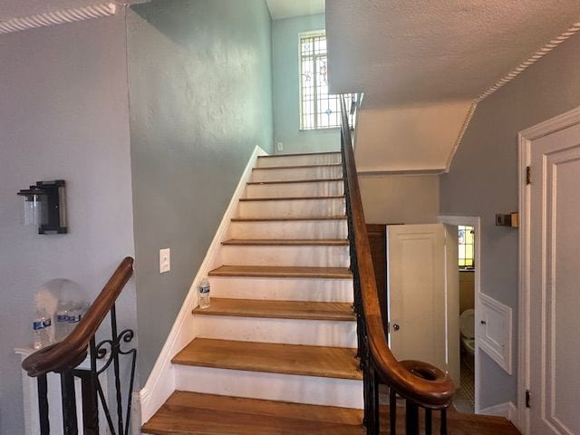 stairs featuring hardwood / wood-style flooring and lofted ceiling