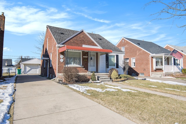 bungalow featuring an outbuilding, a porch, a garage, and a front lawn