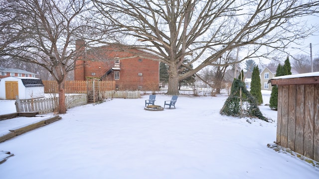 yard covered in snow featuring a fire pit