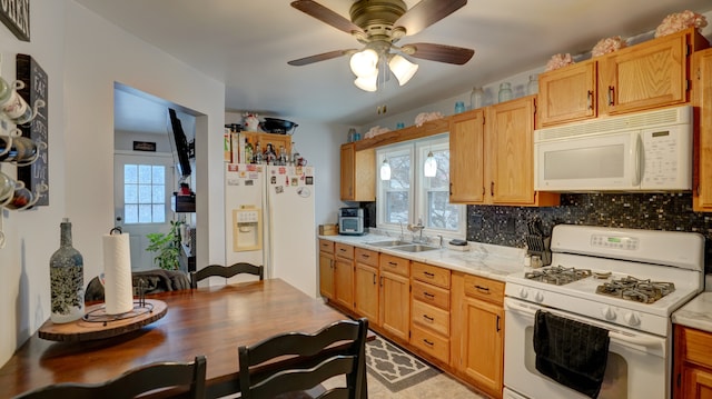 kitchen featuring tasteful backsplash, sink, white appliances, and a healthy amount of sunlight