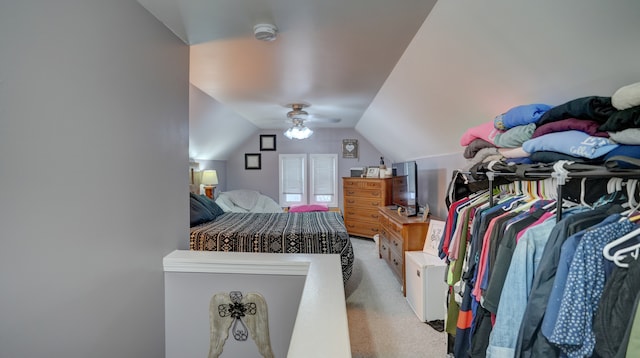 bedroom featuring vaulted ceiling, light carpet, and ceiling fan