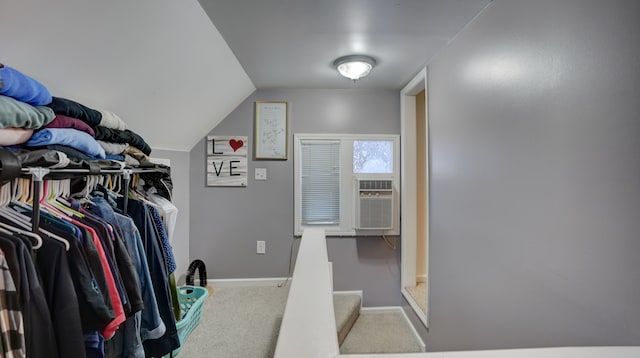 spacious closet featuring cooling unit, lofted ceiling, and carpet flooring