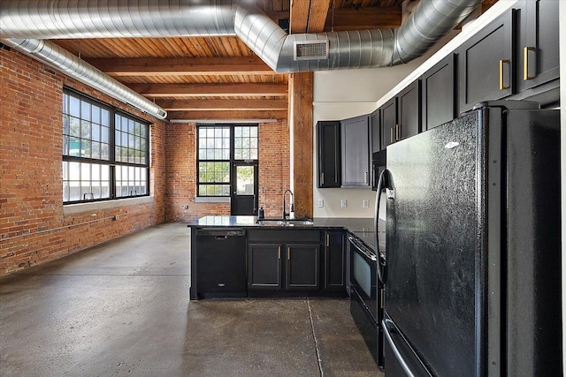 kitchen featuring sink, black appliances, beamed ceiling, and brick wall