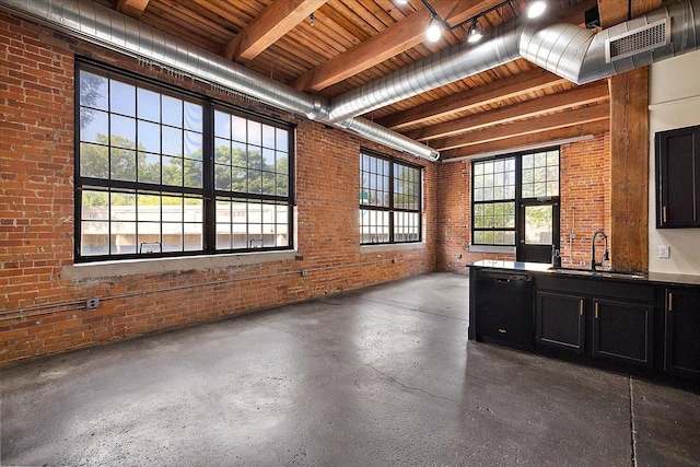 interior space featuring sink, beamed ceiling, black dishwasher, and brick wall