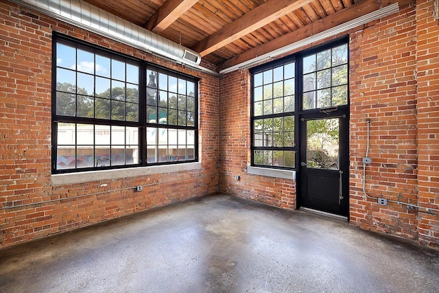 unfurnished room featuring wood ceiling, beam ceiling, and brick wall