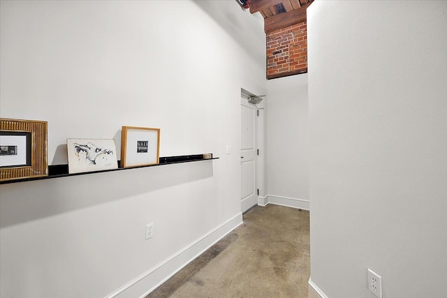 hall featuring brick ceiling and beamed ceiling