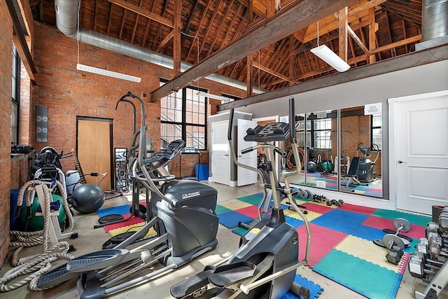 exercise room featuring high vaulted ceiling