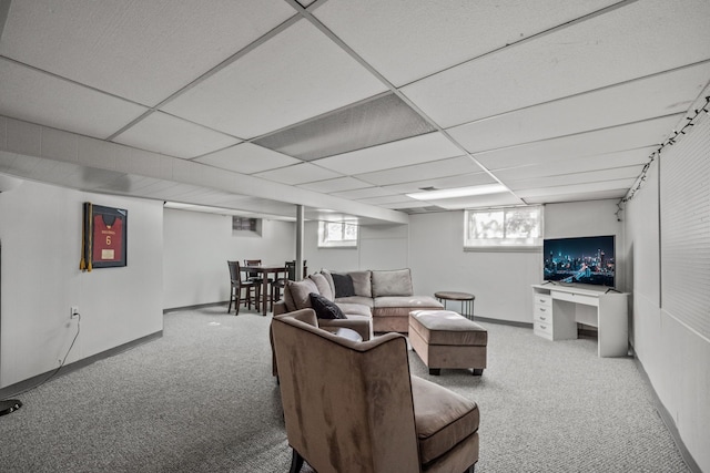 carpeted living room featuring a healthy amount of sunlight and a drop ceiling