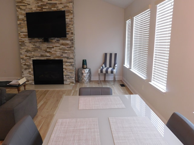 living room featuring light hardwood / wood-style flooring, a fireplace, and plenty of natural light