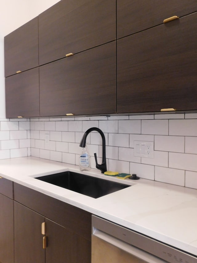 kitchen with tasteful backsplash, sink, dark brown cabinetry, and dishwasher