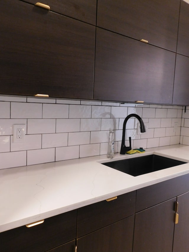 kitchen featuring tasteful backsplash, sink, and dark brown cabinetry