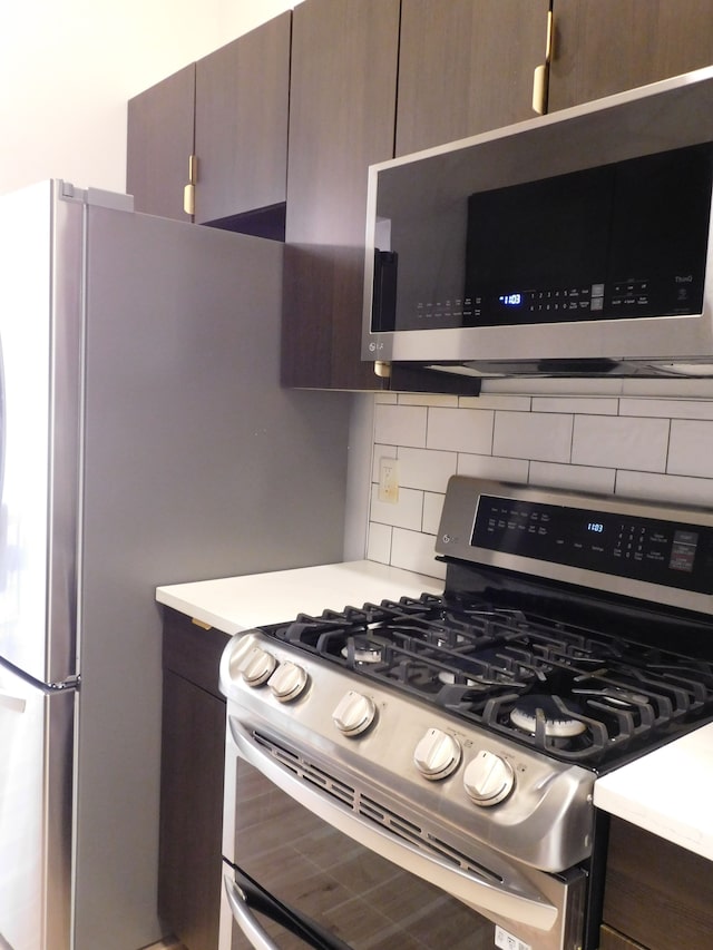 kitchen featuring dark brown cabinetry, tasteful backsplash, and stainless steel appliances