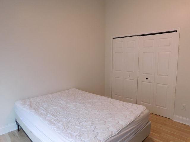 bedroom with light wood-type flooring and a closet