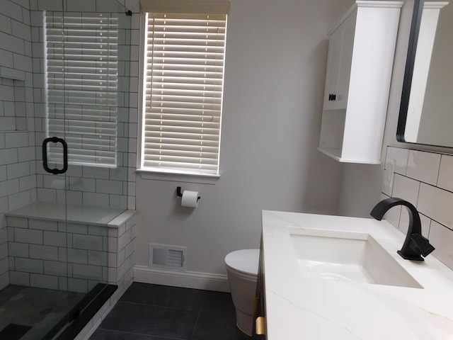 bathroom featuring tile patterned flooring, a shower with door, a wealth of natural light, and toilet