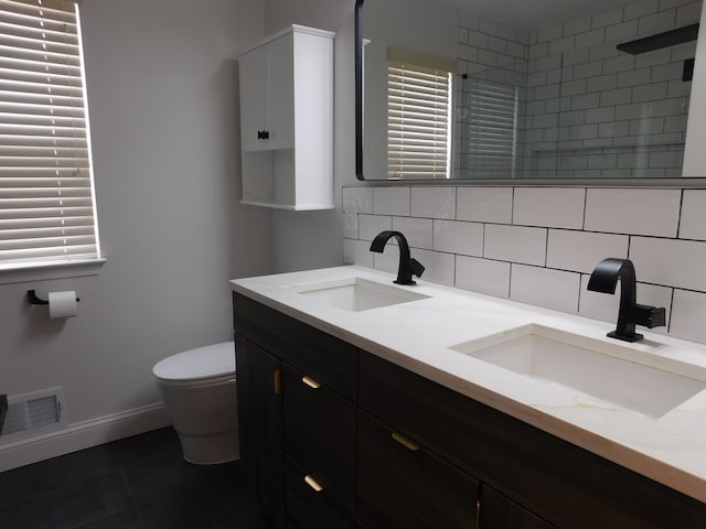 bathroom featuring vanity, backsplash, toilet, and tiled shower