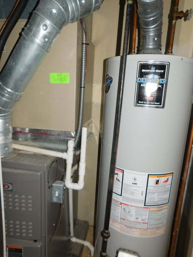 utility room featuring gas water heater and heating unit