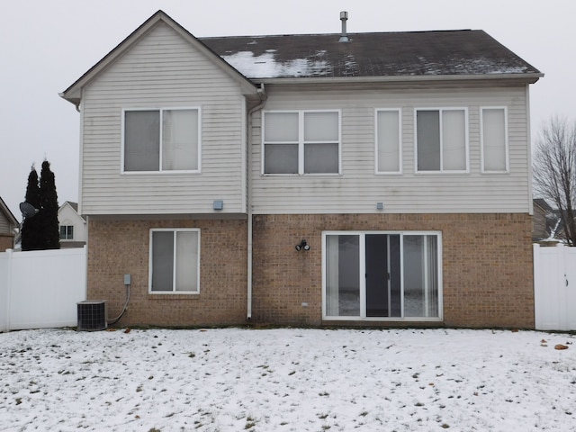 snow covered property with central AC