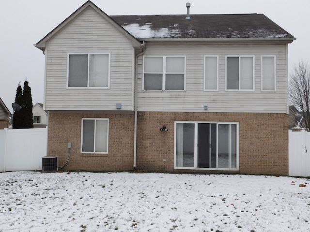 snow covered house with central air condition unit