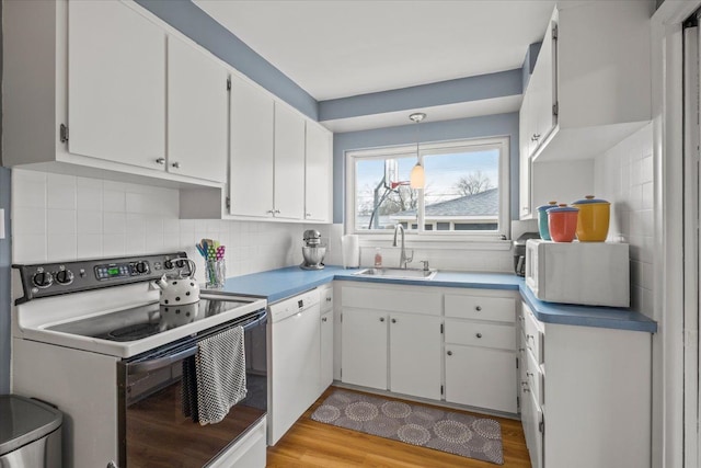 kitchen with pendant lighting, white cabinetry, sink, backsplash, and white appliances