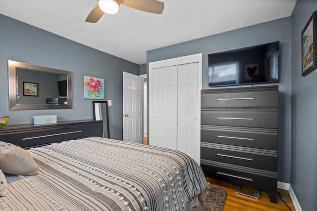 bedroom featuring hardwood / wood-style flooring, ceiling fan, and a closet