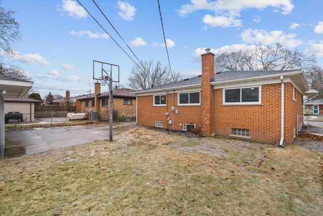 rear view of property with a yard and central AC unit