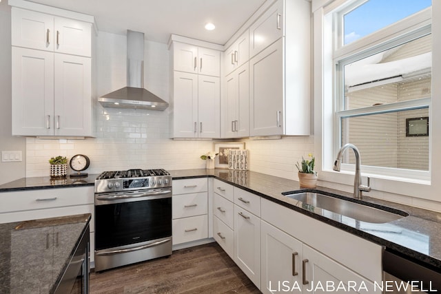 kitchen featuring stainless steel appliances, white cabinetry, and wall chimney exhaust hood